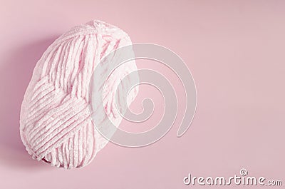 A skein of light pink yarn on a pink background top view is a place for text. Stock Photo