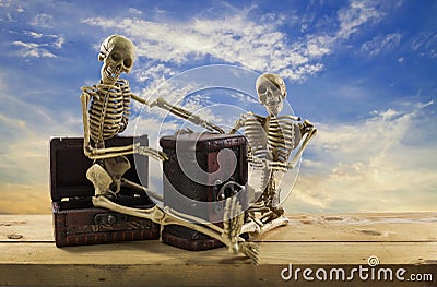 Skeleton pirate sitting on a treasure chest and old wood floor,blue sky background. Stock Photo