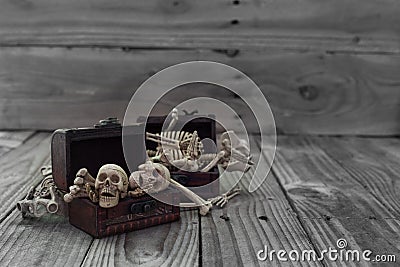 Skeleton pirate in a treasure chest and old wood floor background. Stock Photo