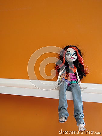Monster Tall doll sitting on white shelf against orange painted wall Editorial Stock Photo