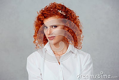 Skeptical. Closeup funny confused doubtful red head curly woman thinking planning looking at you camera isolated on gray wall Stock Photo