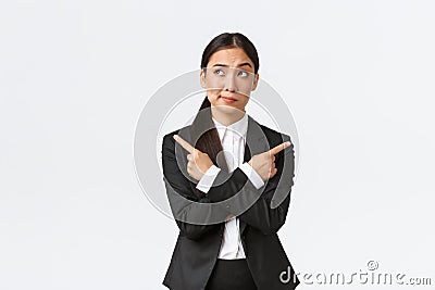 Skeptical and doubtful asian businesswoman hesitating making decision, smirk uncertain looking upper left corner while Stock Photo