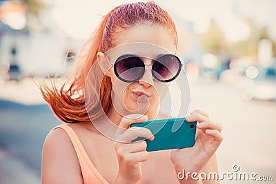 Skeptical, doubtful shocked anxious scared young girl looking at phone Stock Photo