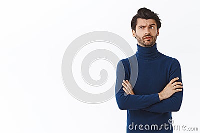 Skeptical, pissed serious-looking male employer in high neck blue sweater, cross arms over chest, smirk and look upper Stock Photo