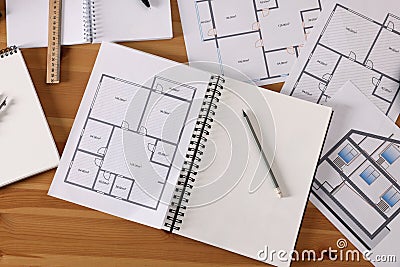 Sketchbook with construction drawings and pencil on wooden table, flat lay Stock Photo