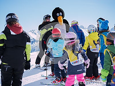 Ski instructor in penguin suit studies young skiers. Ski resort in Alps, Austria, Zams on 22 Feb 2015. Skiing, winter season, moun Editorial Stock Photo
