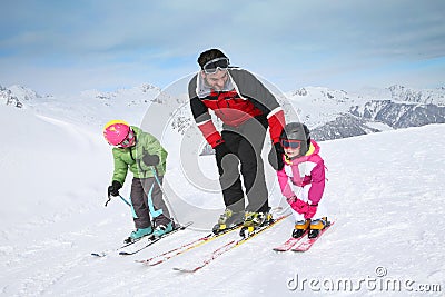 Ski instructor teaching children skiing Stock Photo