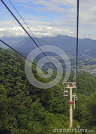 Ski lift in the mountains carrying passengers to hiking trail Stock Photo