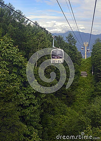 Ski lift in the mountains carrying passengers to hiking trail Stock Photo