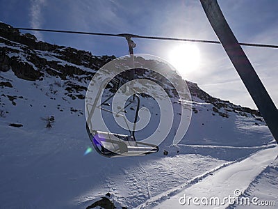 Ski lift sit above ski empty slope in italian Dolomites in winter sunny blue sky day Stock Photo