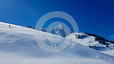 Ski mountaineer hiking up a summit in the Austrian Alps on a beautiful winter day. Walsertal, Vorarlberg, Austria. Stock Photo