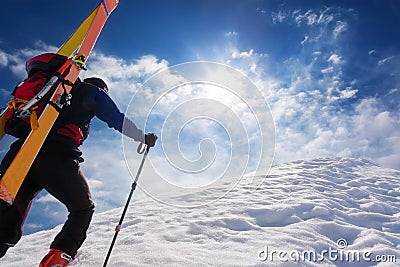 Ski mountaineer walking up along a steep snowy ridge with the s Stock Photo