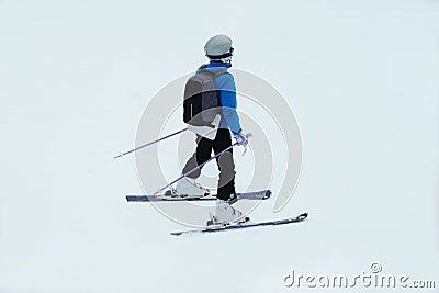 Ski sports in winter. Skier in blue ski suit rises on lift up mountain slope. Vacation in mountains in ski resort. Stock Photo