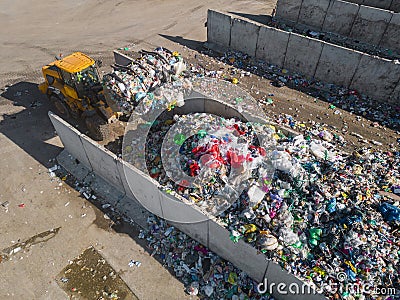 Skid steer loader moving waste material, shaking out a scrap grapple Stock Photo