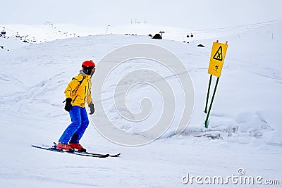 Skier goes to warning signs of danger on crossroads. Stock Photo