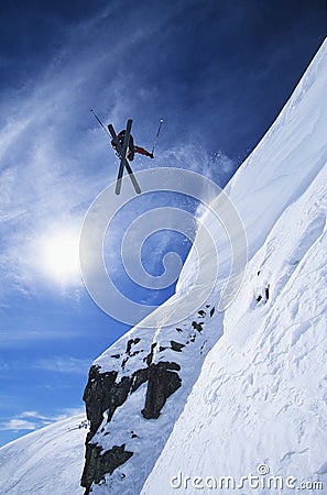 Skier Jumping From Mountain Ledge Stock Photo