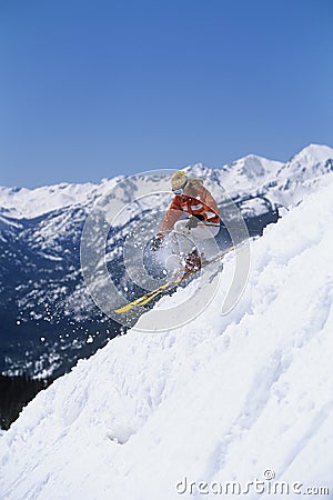Skier Skiing Down Ski Slope Stock Photo