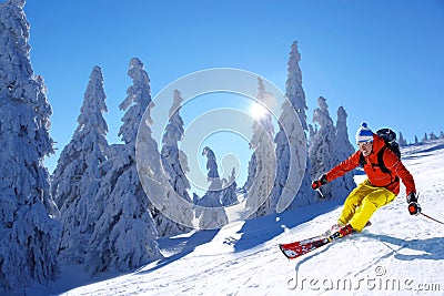 Skier skiing downhill in high mountains against sunset Stock Photo