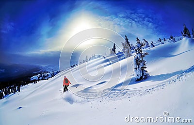 Skier skiing downhill in high mountains against sunset Stock Photo