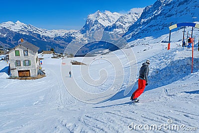 Skier skiing downhill in high mountains Kleine Scheidegg station at Switzerland Editorial Stock Photo