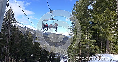 Skiers, snowboarders riding on a ski lift, transportation to mountain ski slopes resort Editorial Stock Photo