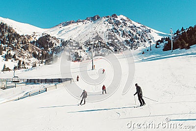 Skiers and snowboarders riding on a ski slope mountain resort Stock Photo