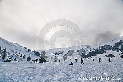 Skiers at snowy ski slope enjoying winter holidays at Kalavryta ski Resort in Greece. Editorial Stock Photo