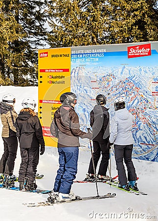 Skiers standing near the plan of the track in the ski resort Editorial Stock Photo