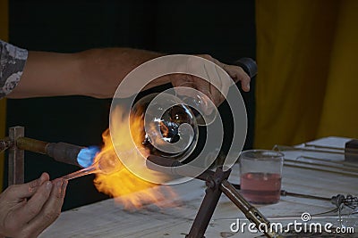 Skilful hands shaping hot and dangerous glass Stock Photo