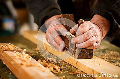 Skilled carpenter using a handheld plane Stock Photo