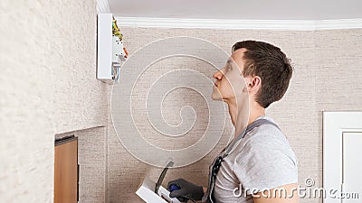 Skilled craftsman covers switchboard with case in hallway Stock Photo