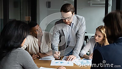 Skilled focused young leader analyzing sales data at brainstorming meeting. Stock Photo