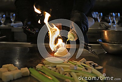 Skilled japanese cook cooking at hibachi grill, tasteful asian food. Fried rice, vegetables, and noodles. Stock Photo