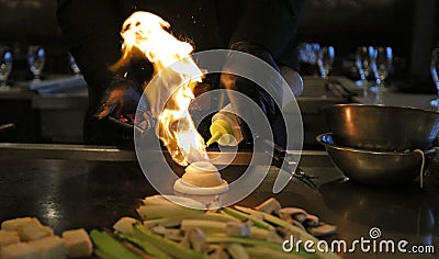 Skilled japanese cook cooking at hibachi grill, tasteful asian food. Fried rice, vegetables, and noodles. Stock Photo