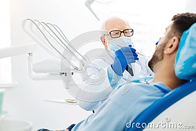 Skilled stomatologist using dental instruments Stock Photo