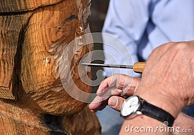 Skilled Wood Carver is working on recreating an old viking statue Editorial Stock Photo