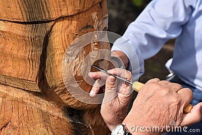 Skilled Wood Carver is working on recreating an old viking statue Editorial Stock Photo