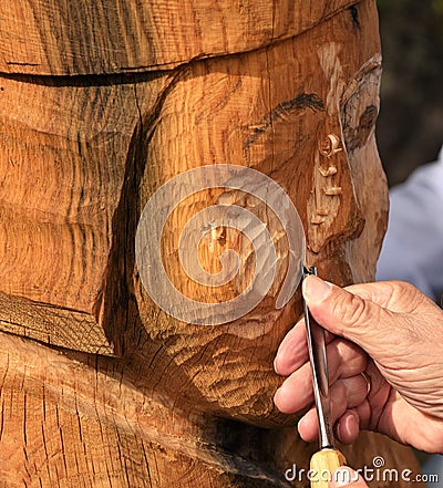 Skilled Wood Carver is working on recreating an old viking statue Editorial Stock Photo