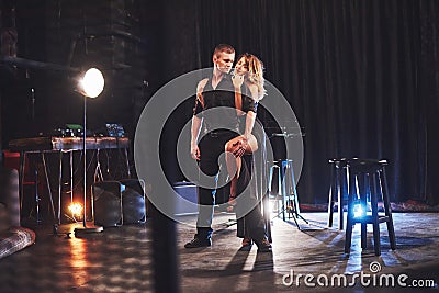 Skillful dancers performing in the dark room under the light Stock Photo