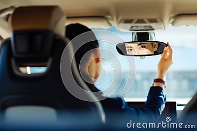 Positive smart woman fixing the rearview mirror Stock Photo