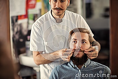 Skillful male barber is serving his client Stock Photo