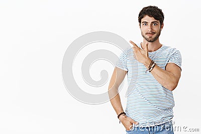 Skillful male entrepreneur showing product to potential customer standing confident and relaxed pointing at upper left Stock Photo