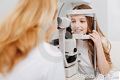 Skillful trained ophthalmologist examining girls eyesight Stock Photo