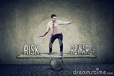 Skillful young business man balancing between reward and risk Stock Photo