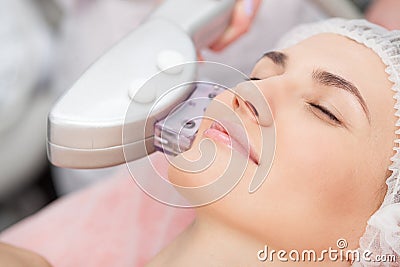 Skillful young cosmetologist is treating female Stock Photo