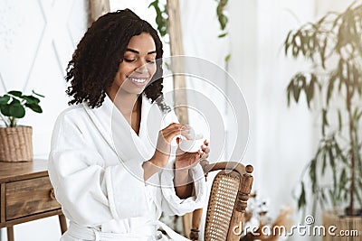 Skin Care. Beautiful Black Girl After Showering Applying Moisturising Cream On Face Stock Photo