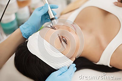 Skin Care. Beautiful Healthy Woman Getting Her Skin Analized By Cosmetologist, Using Skin Analyzer Professional Beauty Equipment Stock Photo