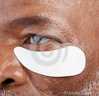 Skin care, eye mask and zoom on black man with professional anti ageing spa treatment with collagen. Dermatology Stock Photo