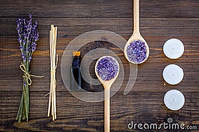 Skin care and relax. Cosmetics and aromatherapy concept. Lavender spa salt and oil on dark wooden background top view Stock Photo