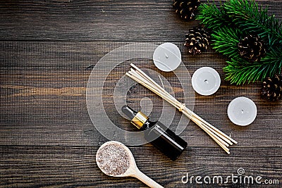 Skin care and relax. Cosmetics and aromatherapy concept. Pine spa salt and oil on dark wooden background top view Stock Photo